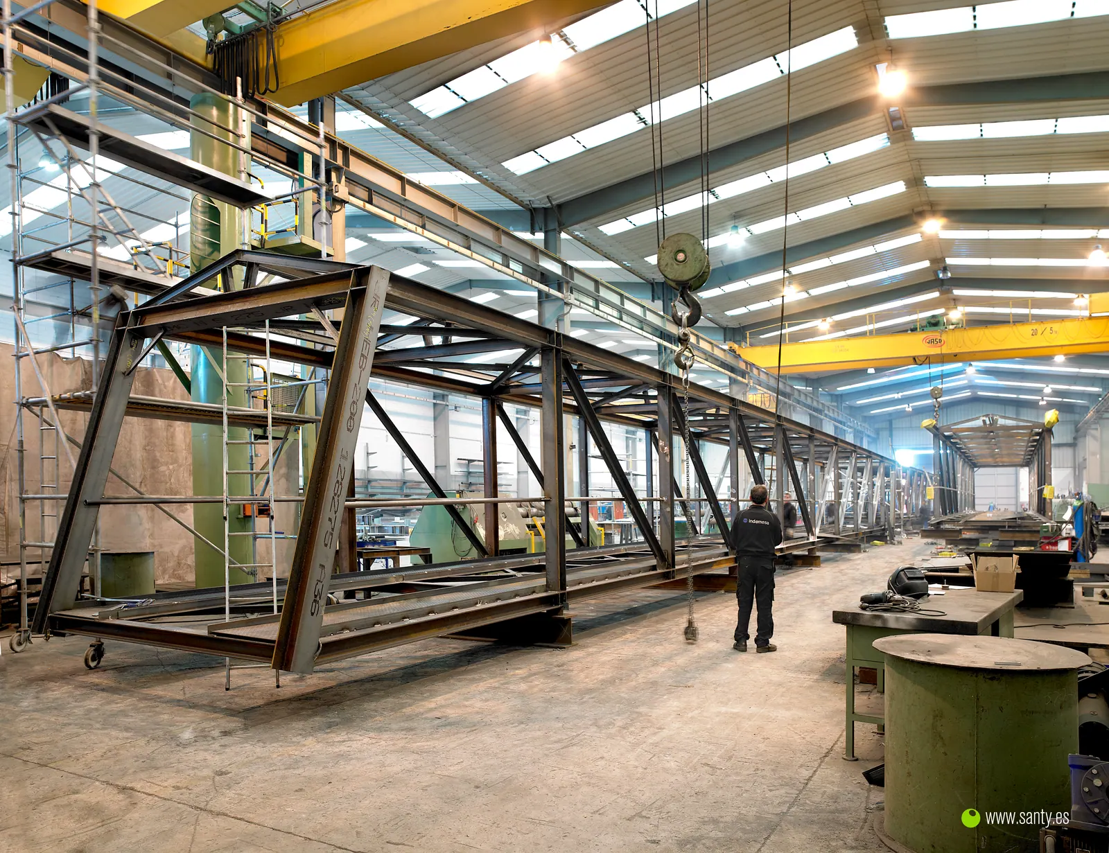 Estructura metálica de gran longitud en fabricación bajo grúa puente