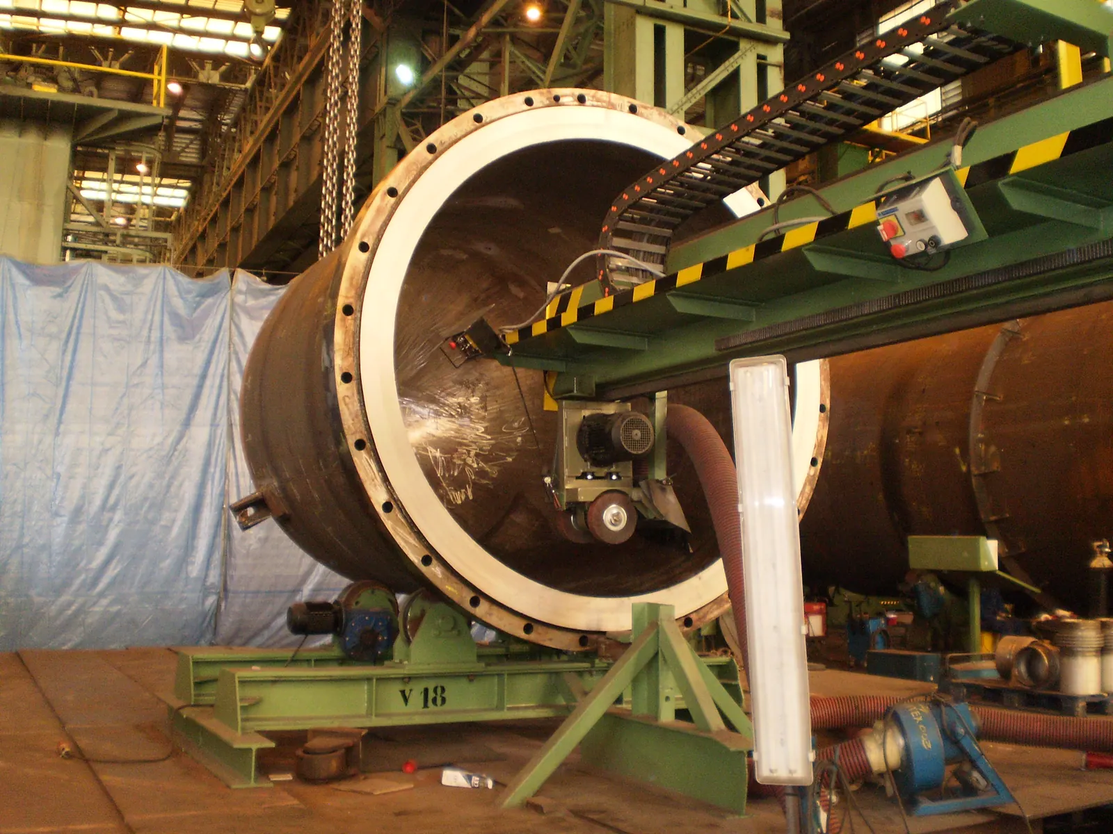 Reactor de gran diámetro con la tapa embridada abierta, sobre bancada en el taller