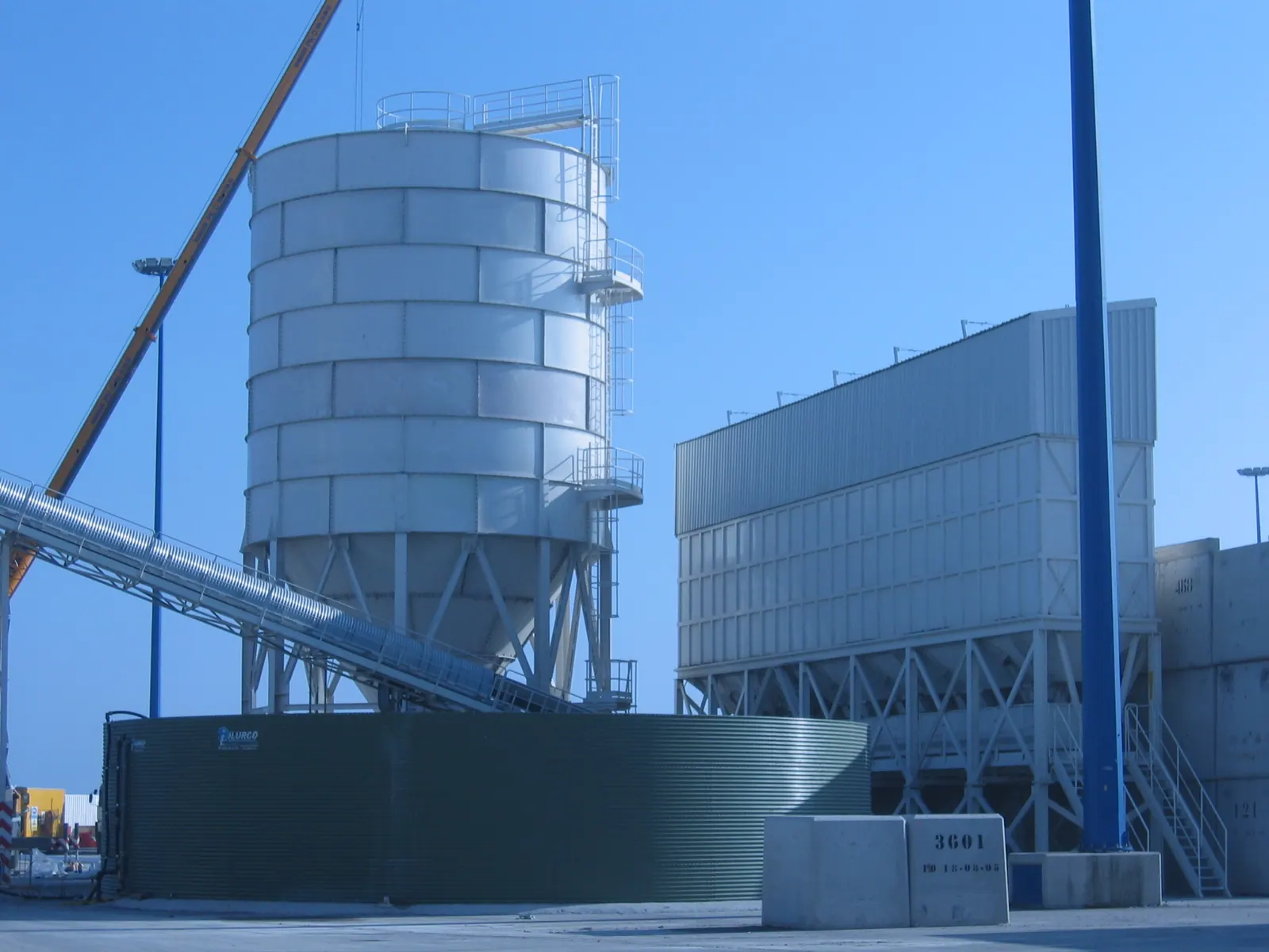 Silo de almacenamiento montado en una planta de graneles, con su escalera de acceso y la cinta de alimentación