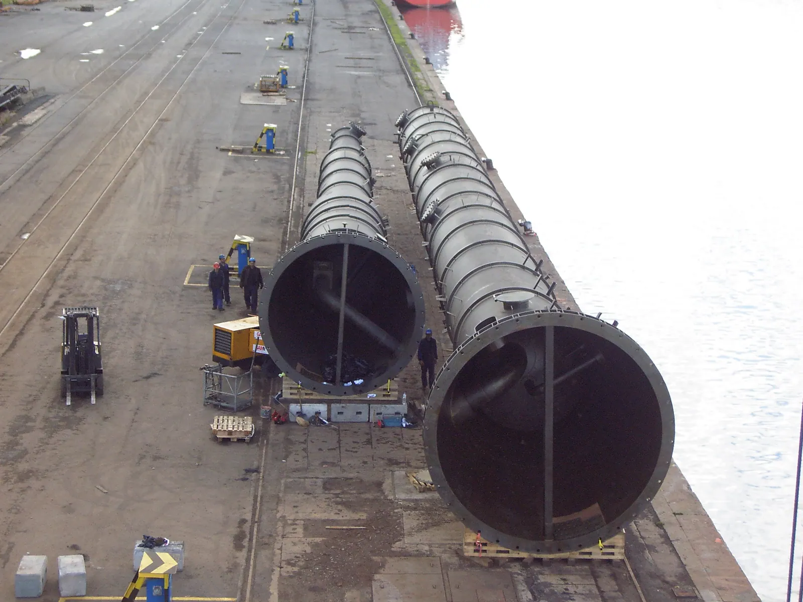 Dos columnas de proceso de gran diámetro tumbadas en el muelle antes de su embarque
