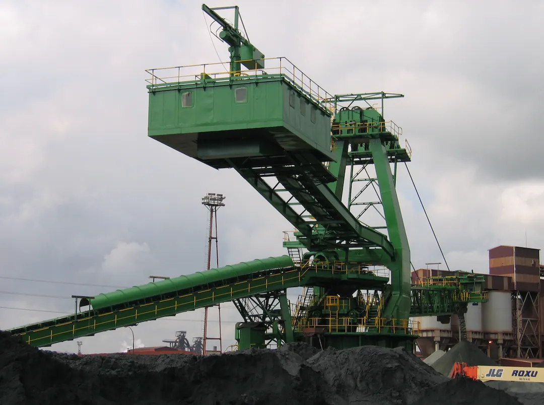 Stacker reclaimer y su cinta transportadora sobre un parque de minerales